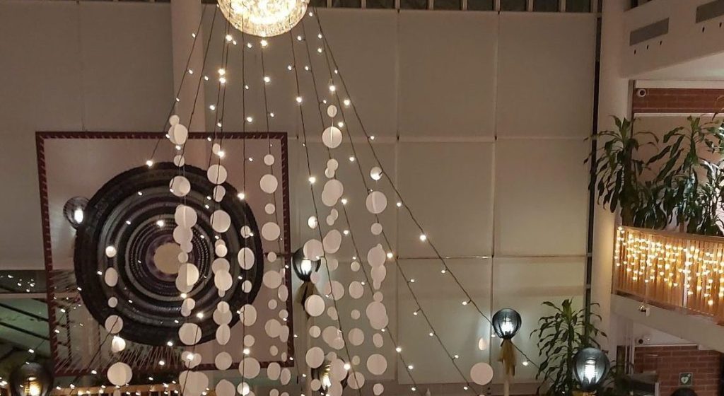 Raision kaupungintalon aula on koristeltu joulukoristein ja valoköynnöksin.